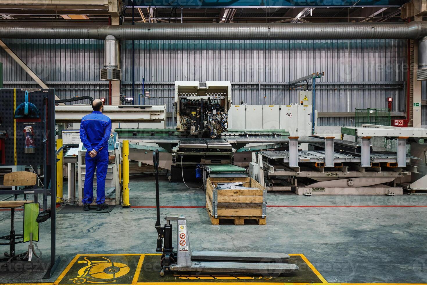 Engineer operates CNC perforation machine photo