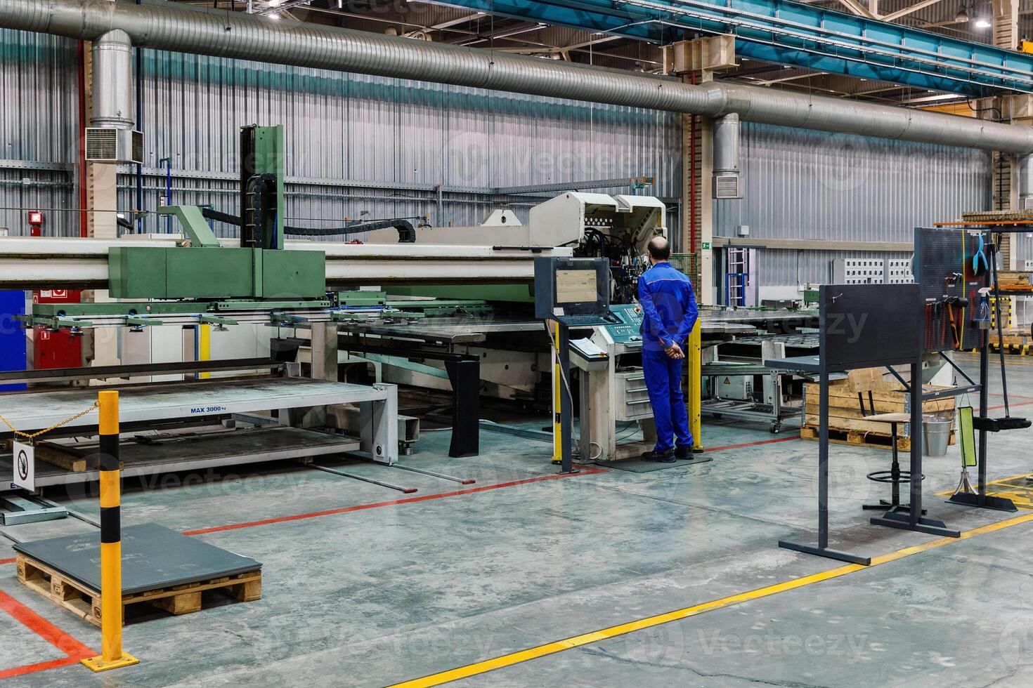 Engineer operates CNC perforation machine photo