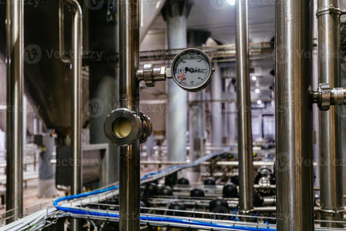 Large industrial stainless steel pipes and pressure gauge in modern brewery photo