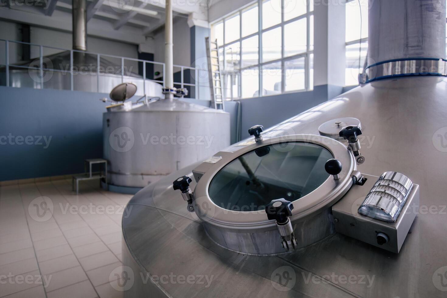 Looking glass of steel tank for beer fermentation in modern brewery photo