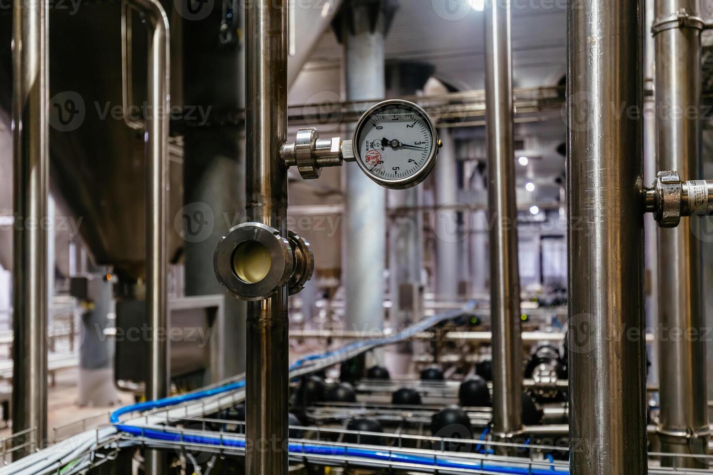 Large industrial stainless steel pipes and pressure gauge in modern brewery photo