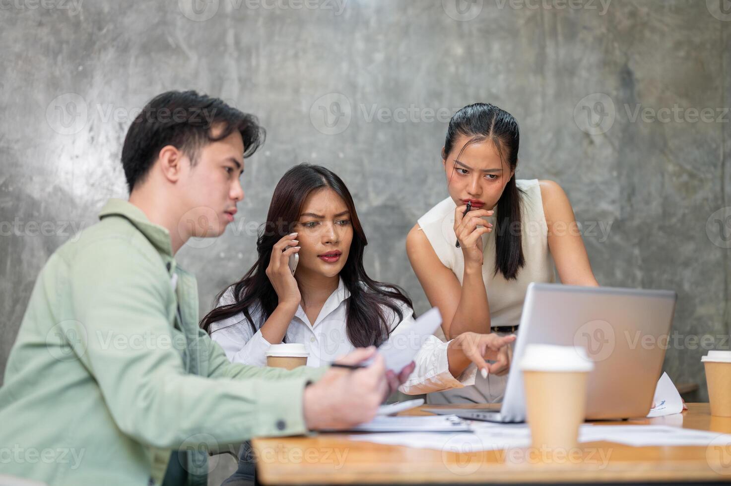 A group of serious, stressed Asian businesspeople is having an intense meeting. photo