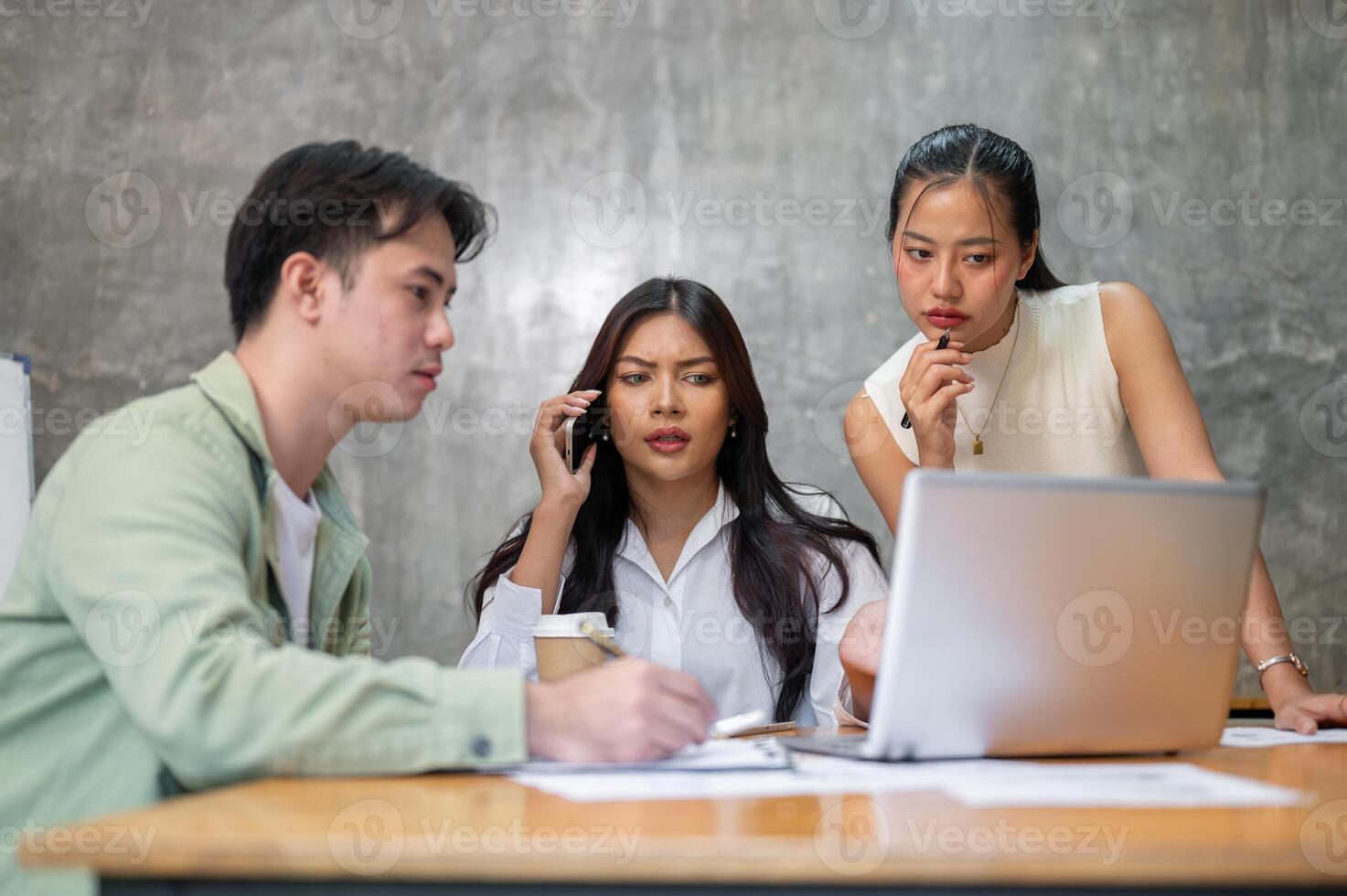 A group of serious, stressed Asian businesspeople is having an intense meeting. photo