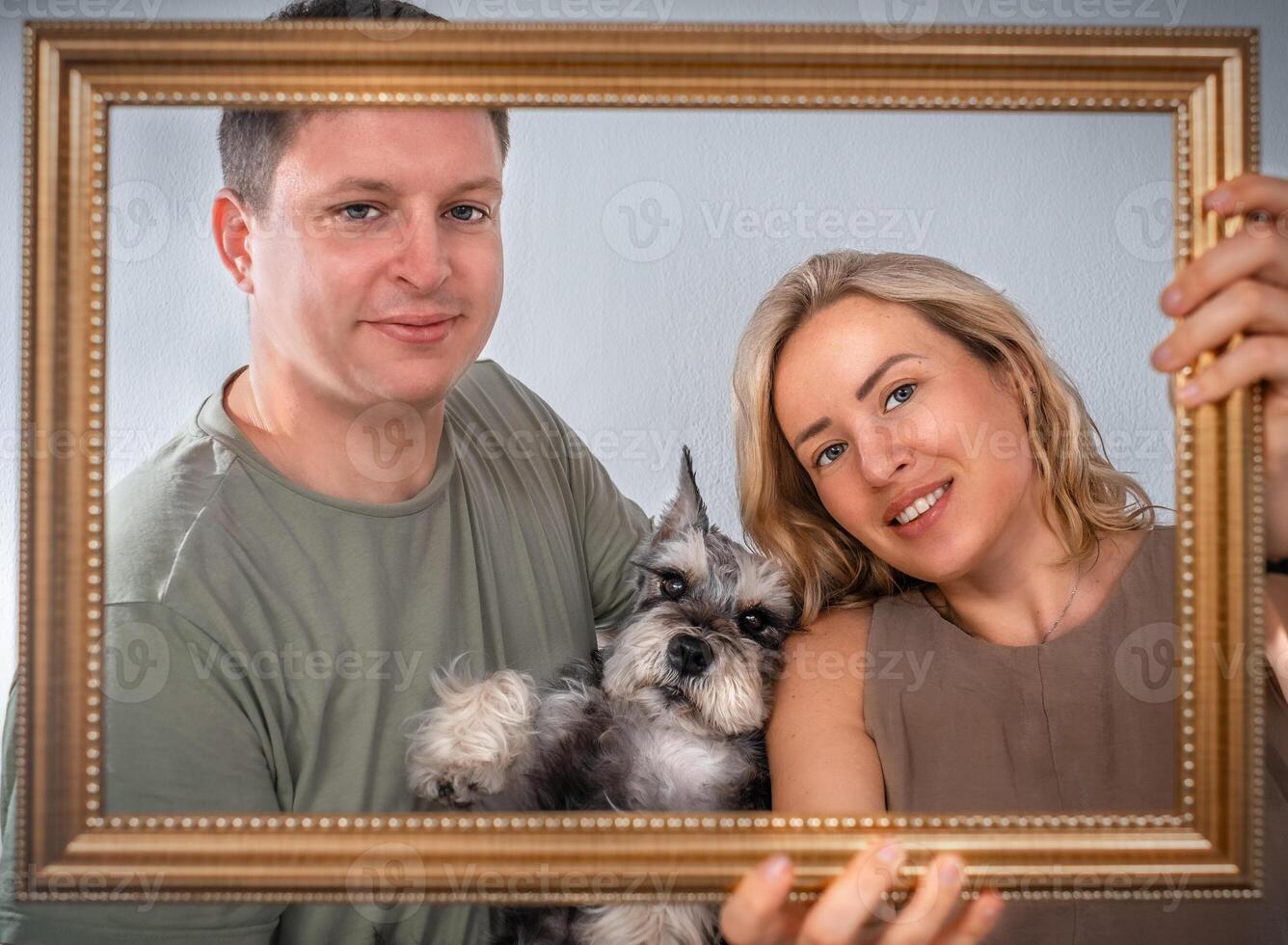 Portrait of a young family with a dog on the frame photo
