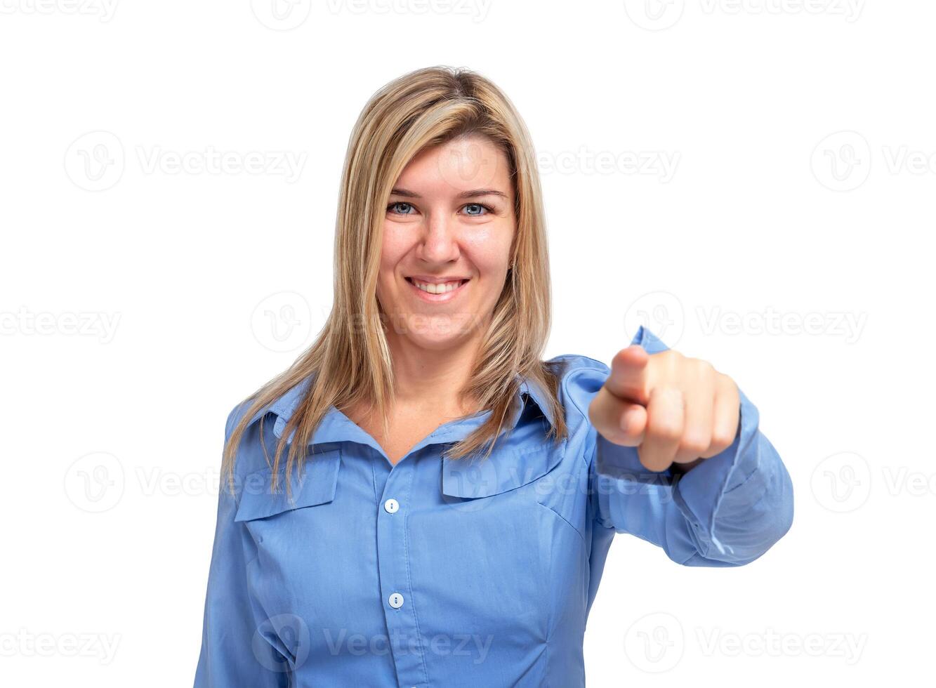 Smiling young woman pointing with index finger at camera isolated photo