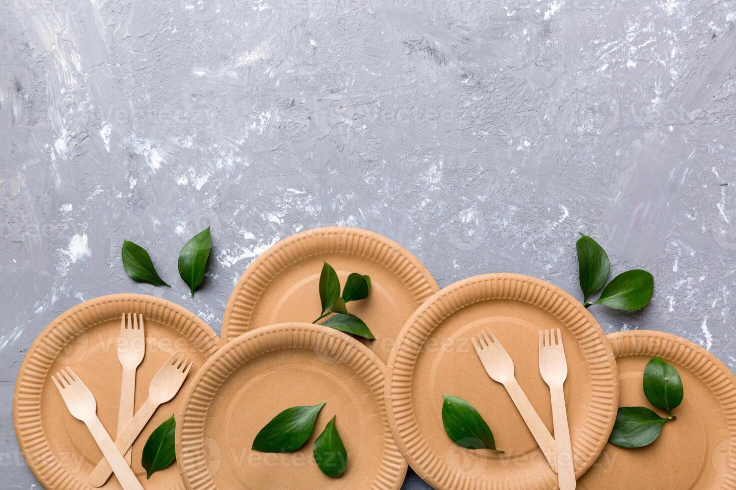 set of empty reusable disposable eco-friendly plates, cups, utensils on light white colored table background. top view. Biodegradable craft dishes. Recycling concept. Close-up photo