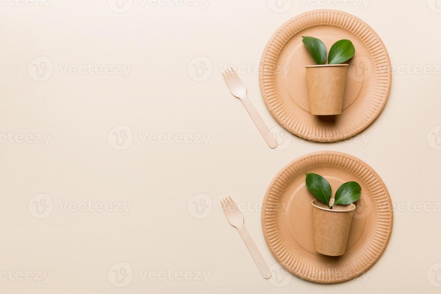 set of empty reusable disposable eco-friendly plates, cups, utensils on light white colored table background. top view. Biodegradable craft dishes. Recycling concept. Close-up photo