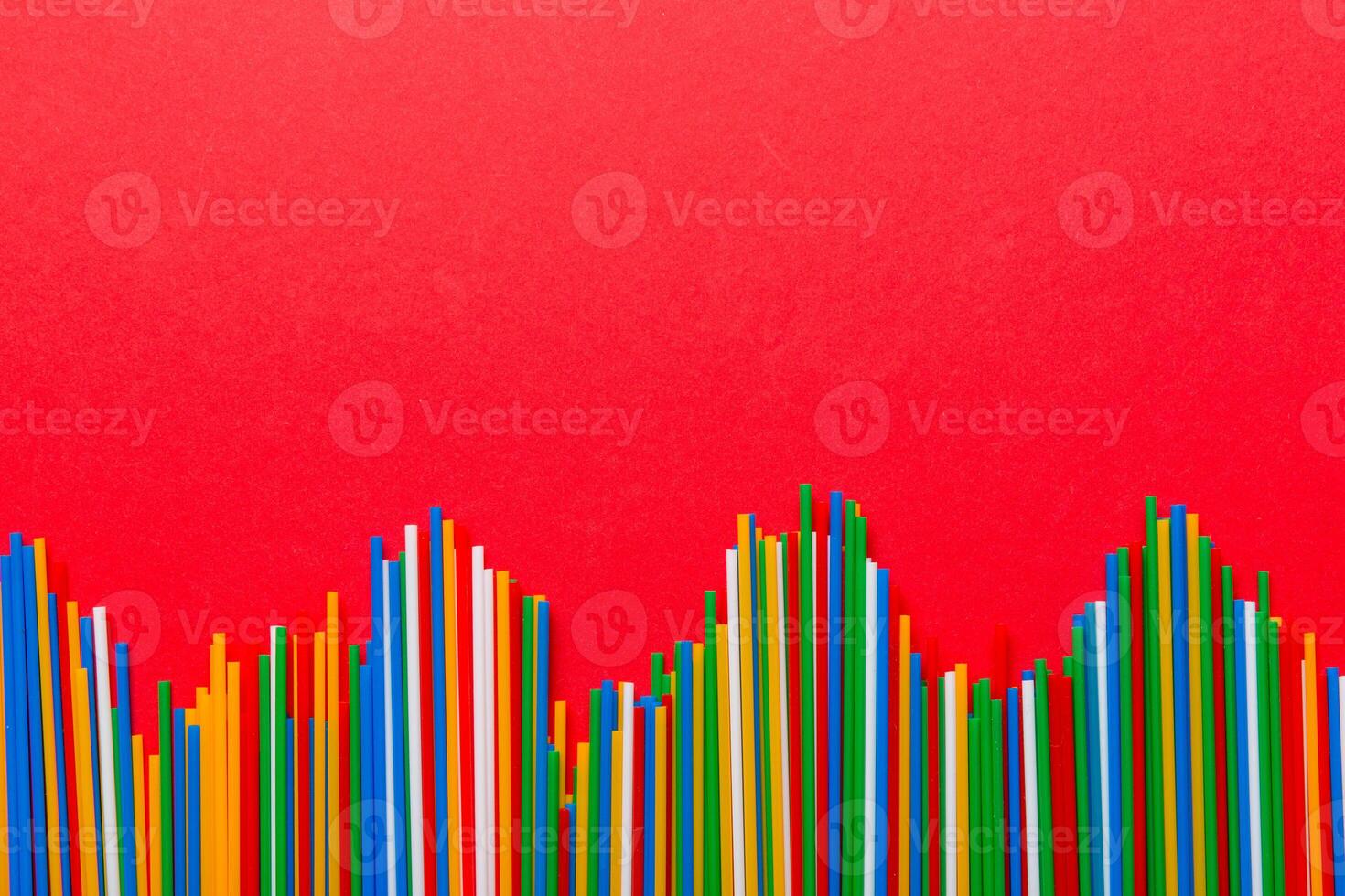 Heap of colorful plastic drinking straws on Colored background, flat lay. Copy Space for text photo