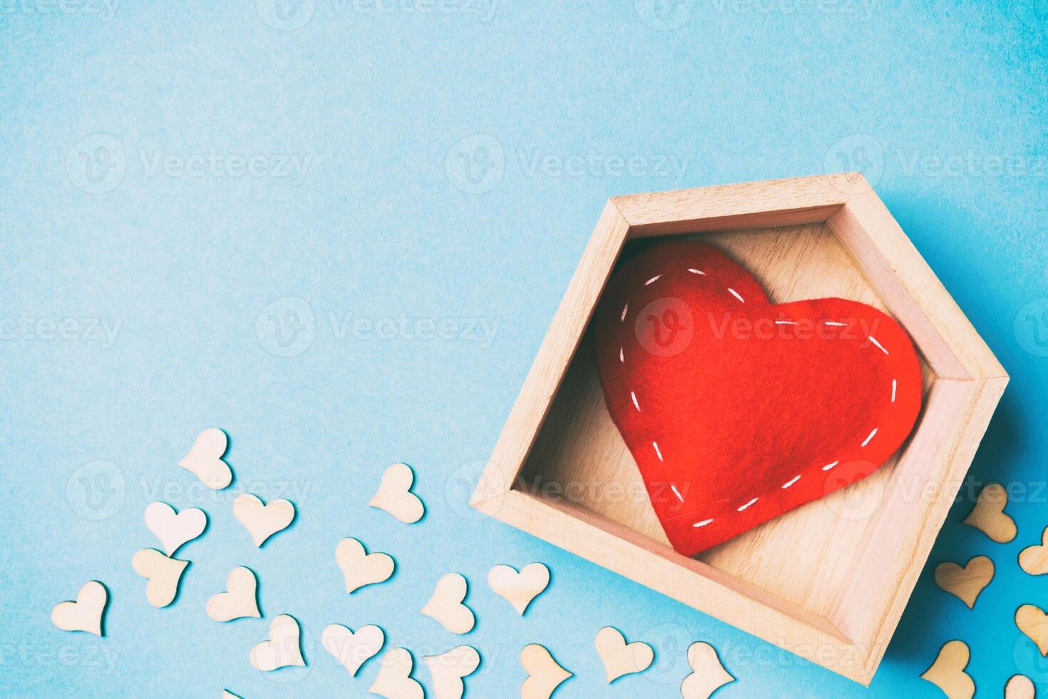 Top view of red textile heart in a wooden house decorated with small hearts on colorful background. Shape of heart. Home sweet home. Valentine's day concept photo