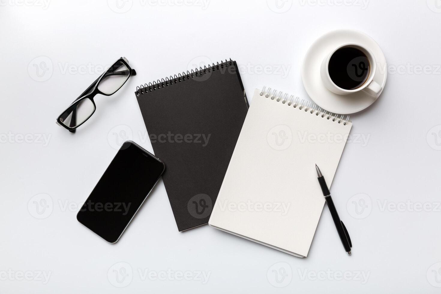 Modern office desk table with notebook, smartphone and other supplies with cup of coffee. Blank notebook page for you design. Top view, flat lay photo