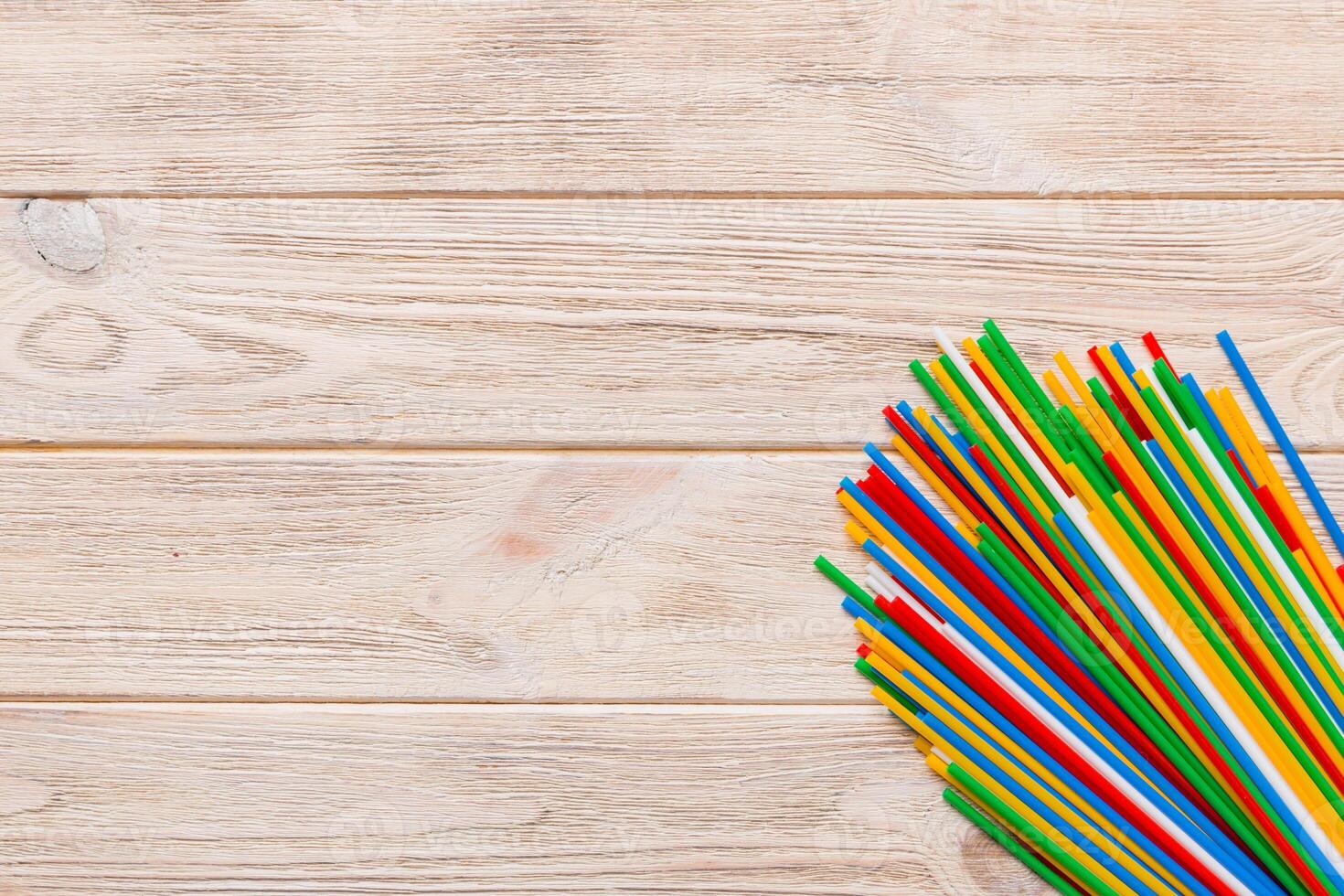 Heap of colorful plastic drinking straws on Colored background, flat lay. Copy Space for text photo