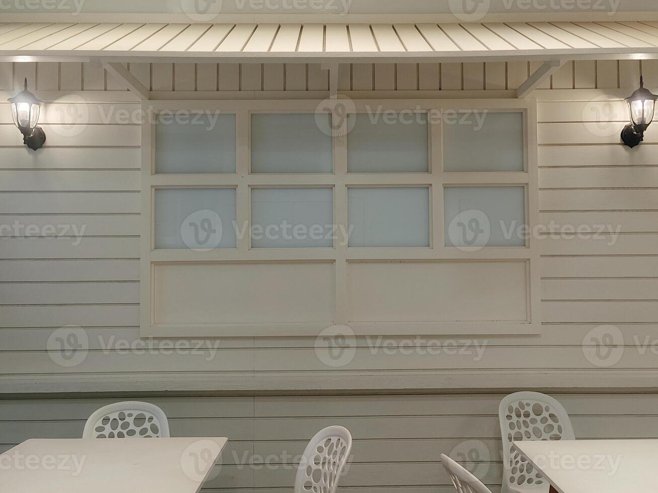 An inviting outdoor seating area with clean white furniture and soft ambient lighting, creating a tranquil and modern atmosphere perfect for relaxation photo