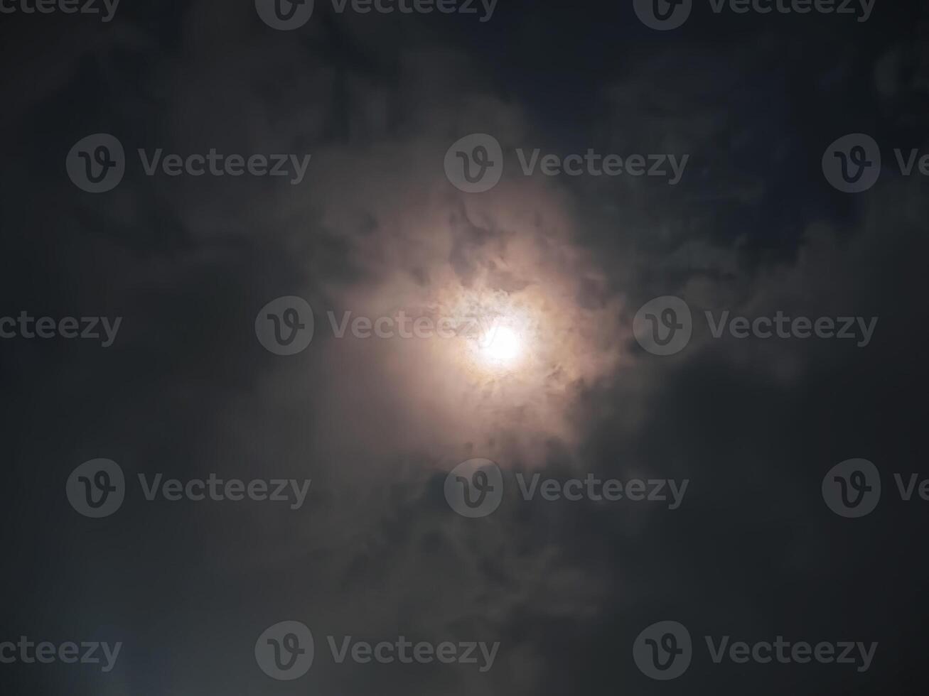 A mesmerizing shot of a full moon glowing through a cloudy night sky, creating a mystical and serene atmosphere photo