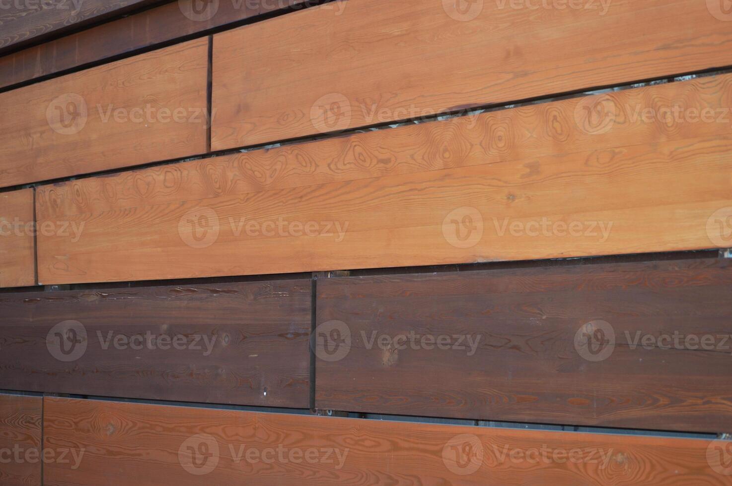 Brown rectangular decorative wooden planks, mirror panels in an abstract pattern. Element of finishing of the building facade. photo