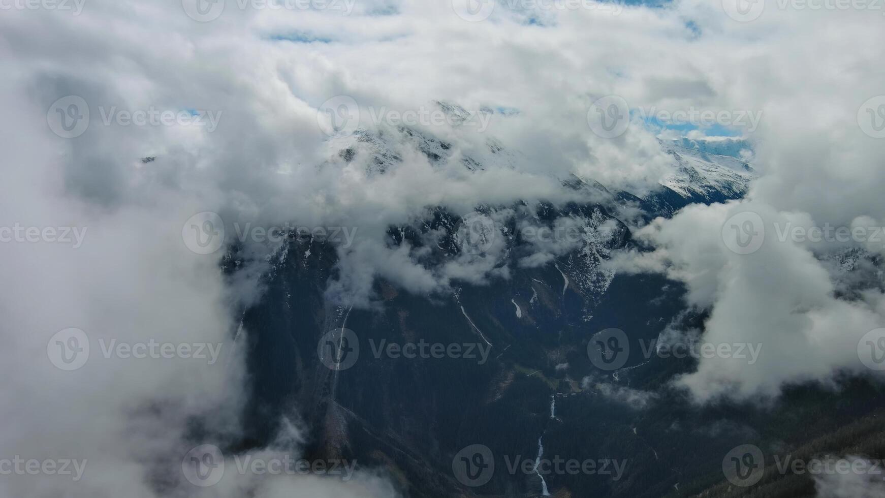 Aerial view of snowcapped mountains in clouds photo