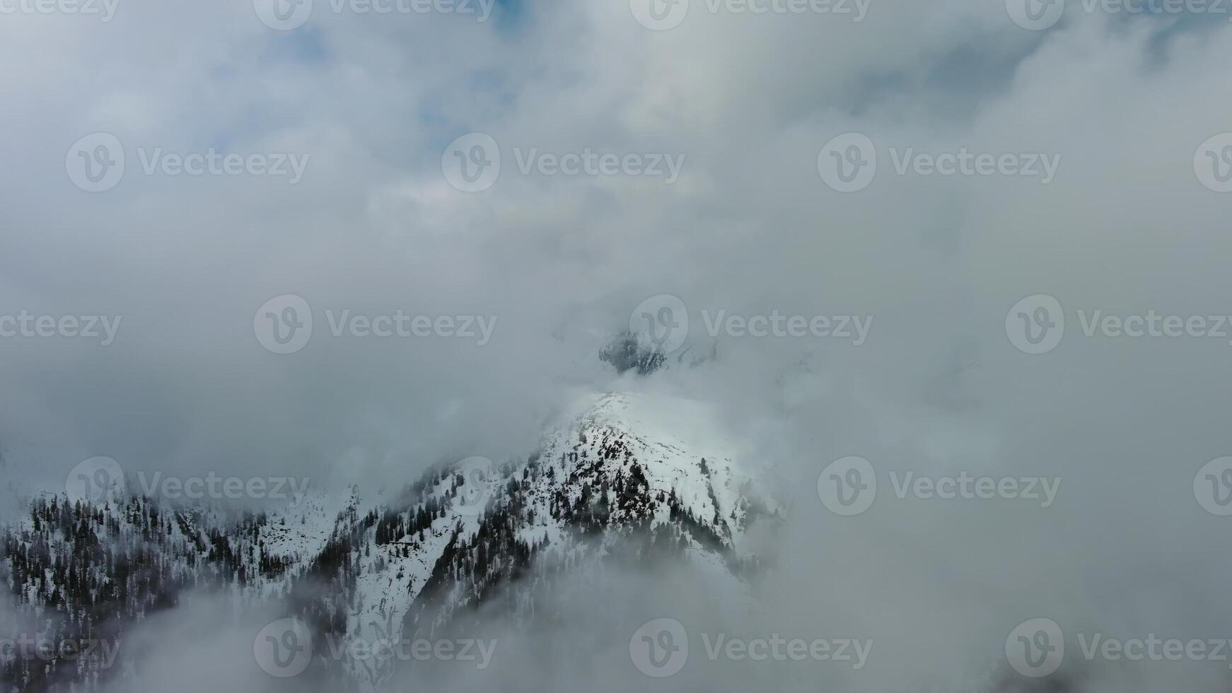 Aerial view of snowcapped mountains in clouds photo
