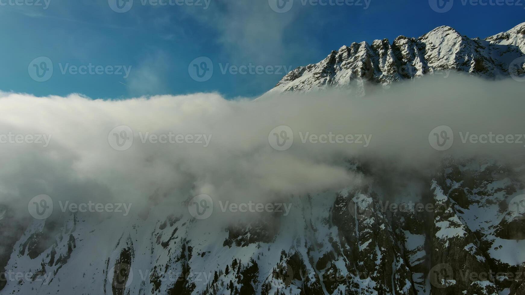 Flying through clouds between mountains photo