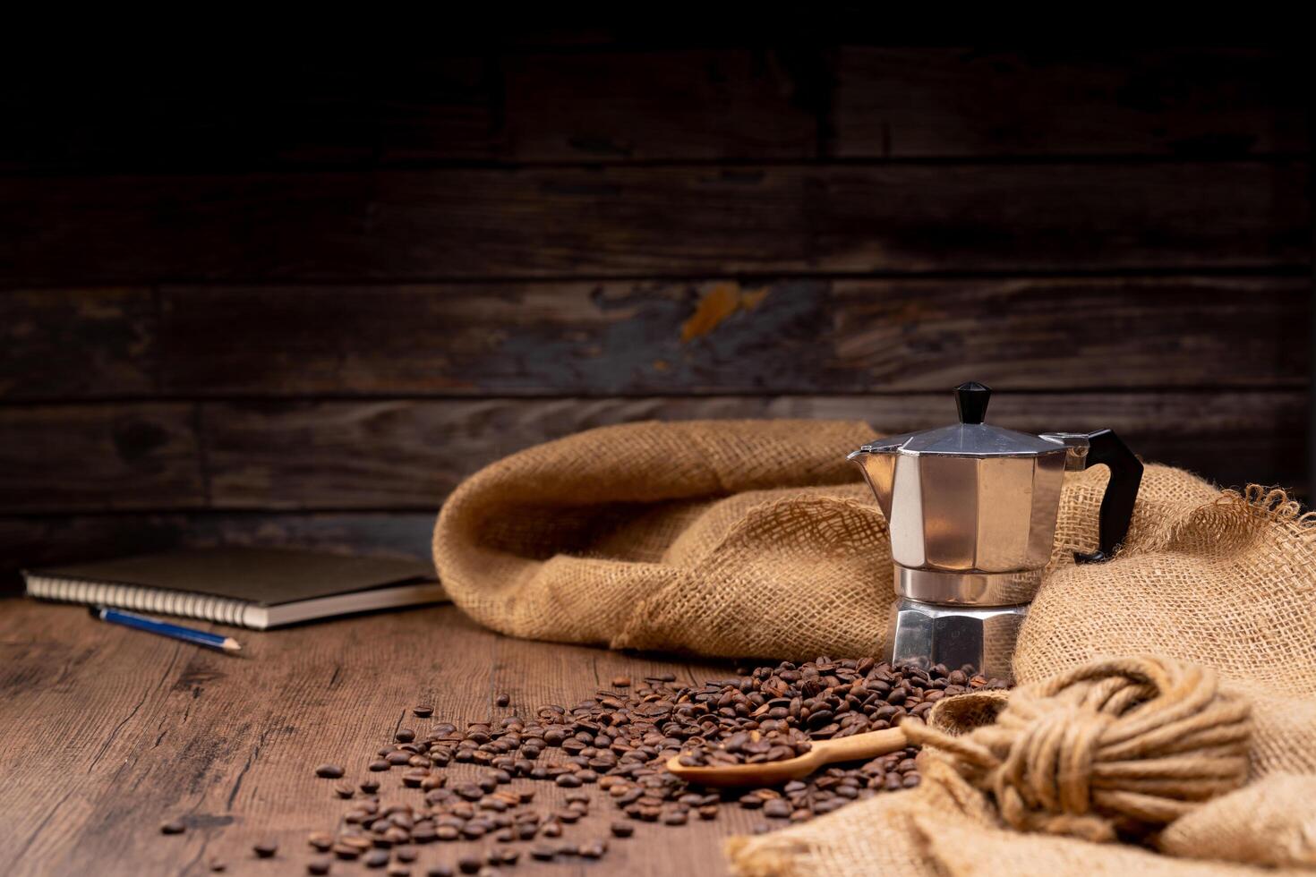 The picture of coffee beans stacked together on a wooden floor in a warm, light atmosphere, on a dark background, with copy space. photo