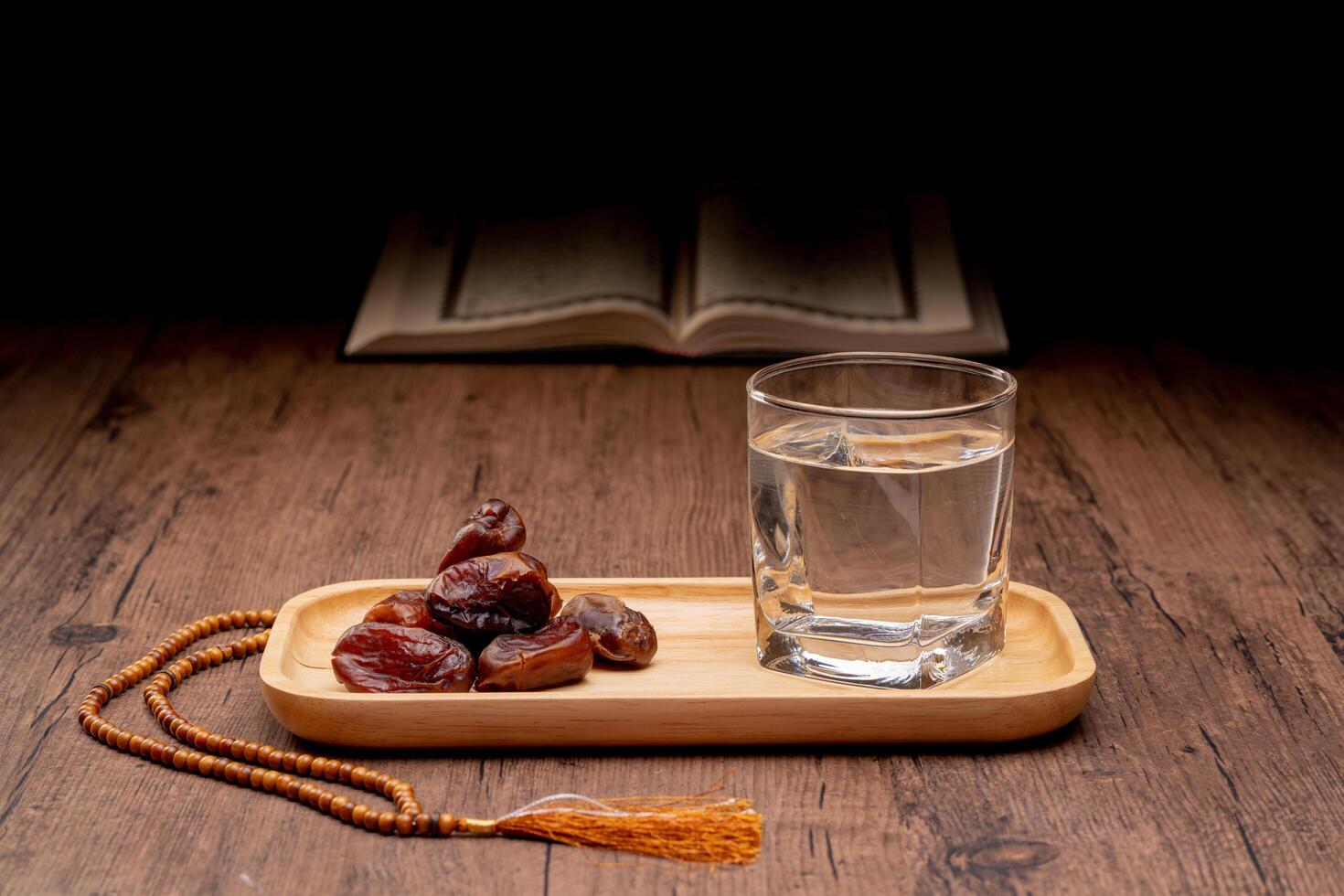 Many Date Palms are on bowls and cups of water and the Quran is on wooden tables, to wait for the time of Iftar, with the concept of ramadan Muslims around the world. photo