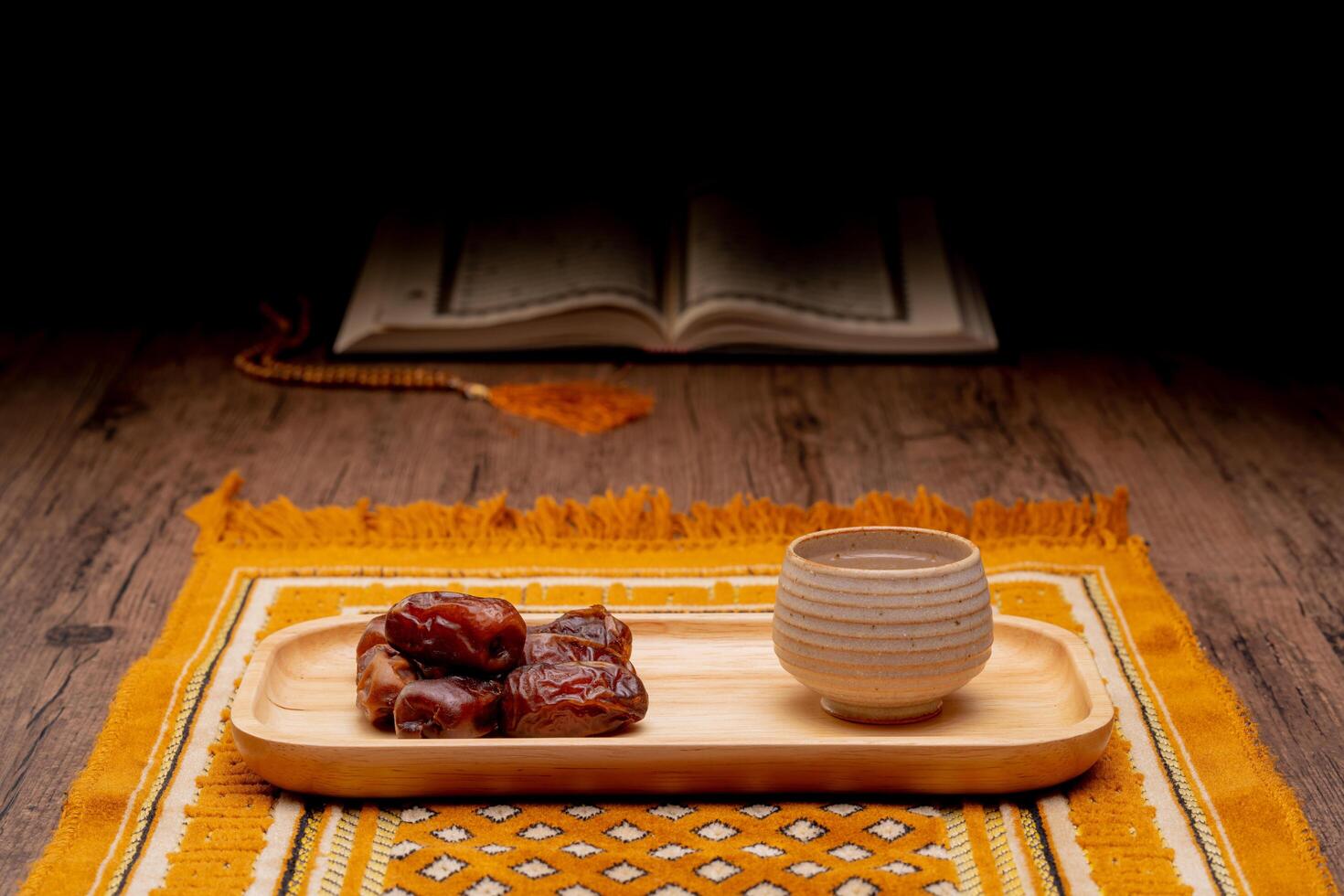 Many Date Palms are on bowls and cups of water and the Quran is on wooden tables, to wait for the time of Iftar, with the concept of ramadan Muslims around the world. photo