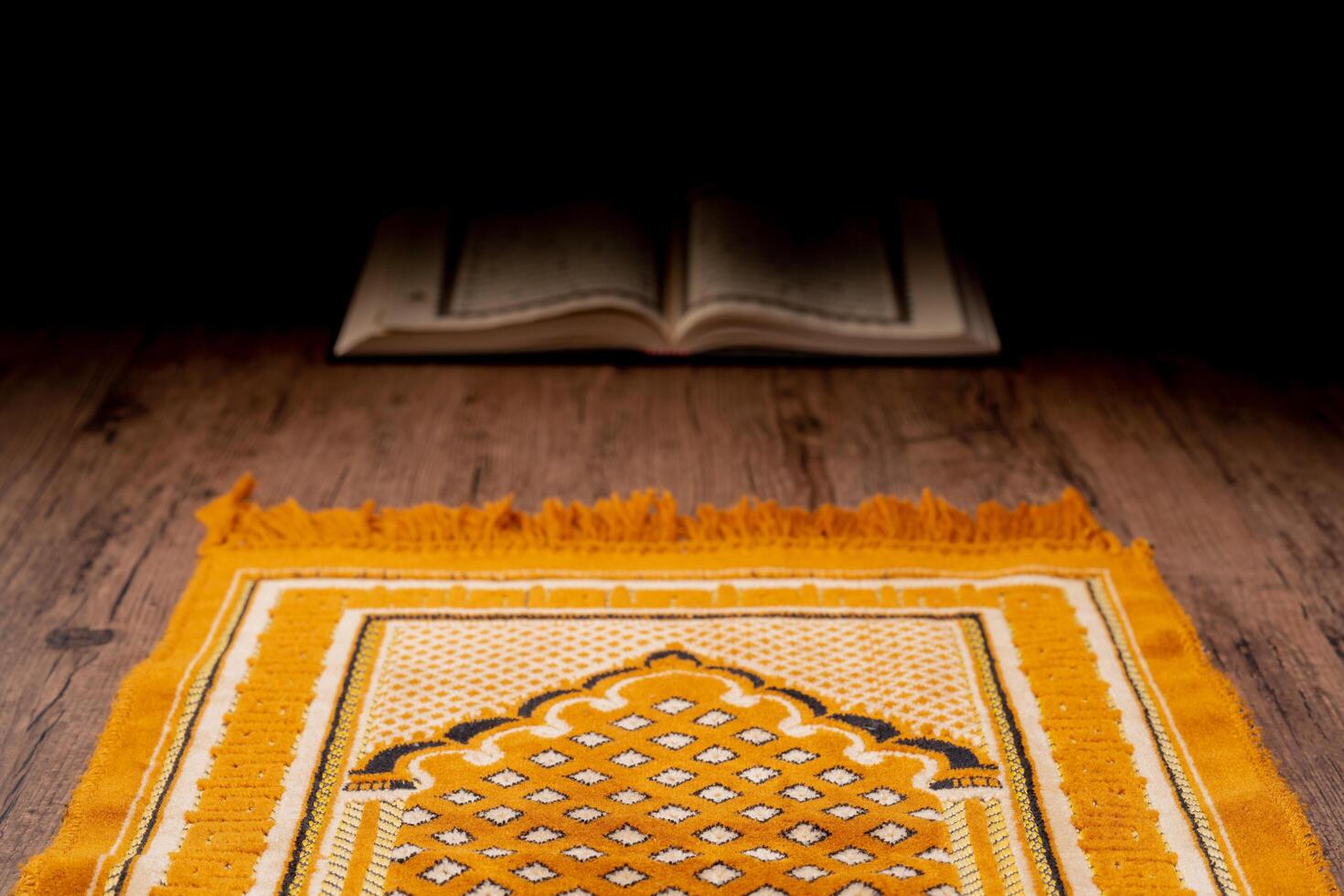 Islamic concept - The Holy Al Quran with written Arabic calligraphy meaning of Al Quran and rosary beads or tasbih and prayer rug, on wooden stand, with copy space. photo