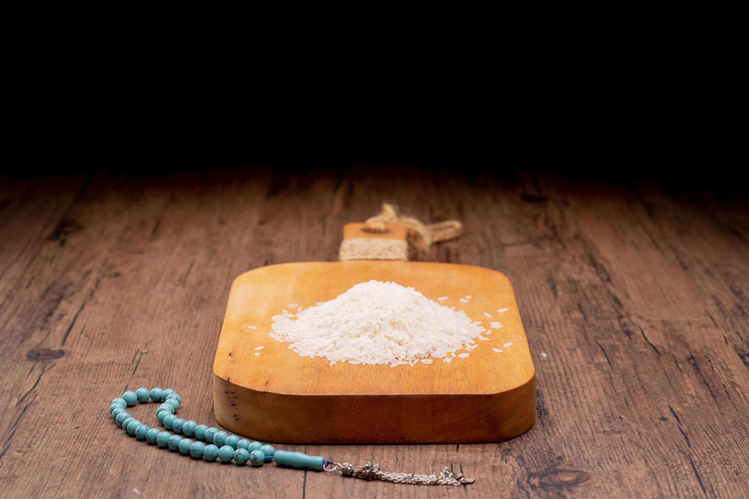 Holy Quran and a grain of rice in a wooden bowl in the sack on a wooden table, Islamic zakat concept. Muslims help the poor and needy. Conceptual shoot for property, income, and fitrah zakat, ramadan. photo