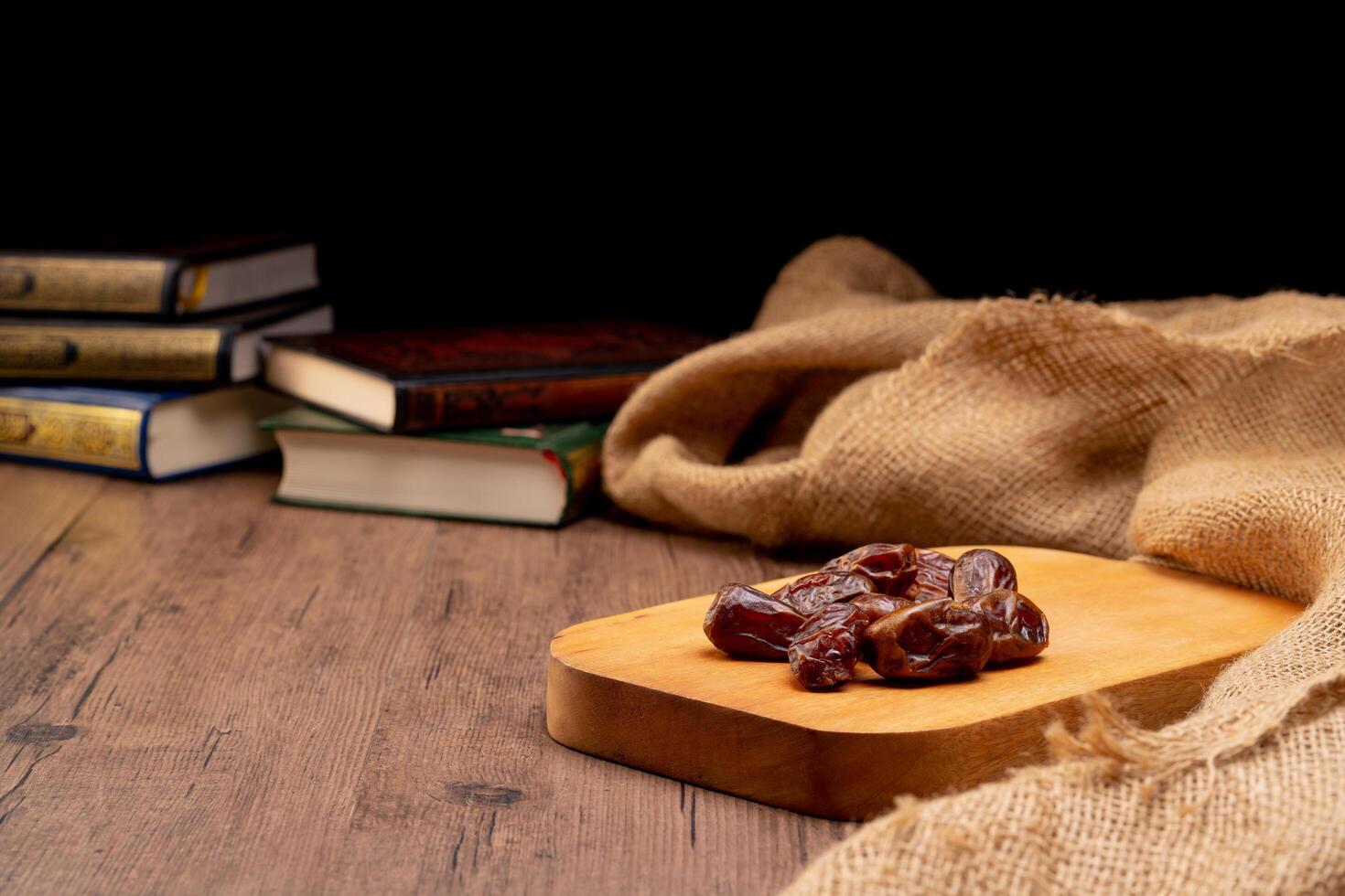 Many Date Palms are on bowls and cups of water and the Quran is on wooden tables, to wait for the time of Iftar, with the concept of ramadan Muslims around the world. photo