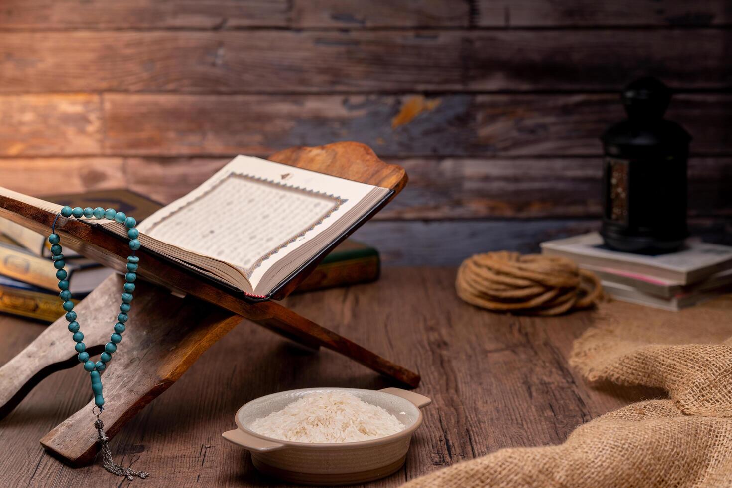 Holy Quran and a grain of rice in a wooden bowl in the sack on a wooden table, Islamic zakat concept. Muslims to help the poor and needy. Conceptual shoot for property, income, and fitrah zakat. photo