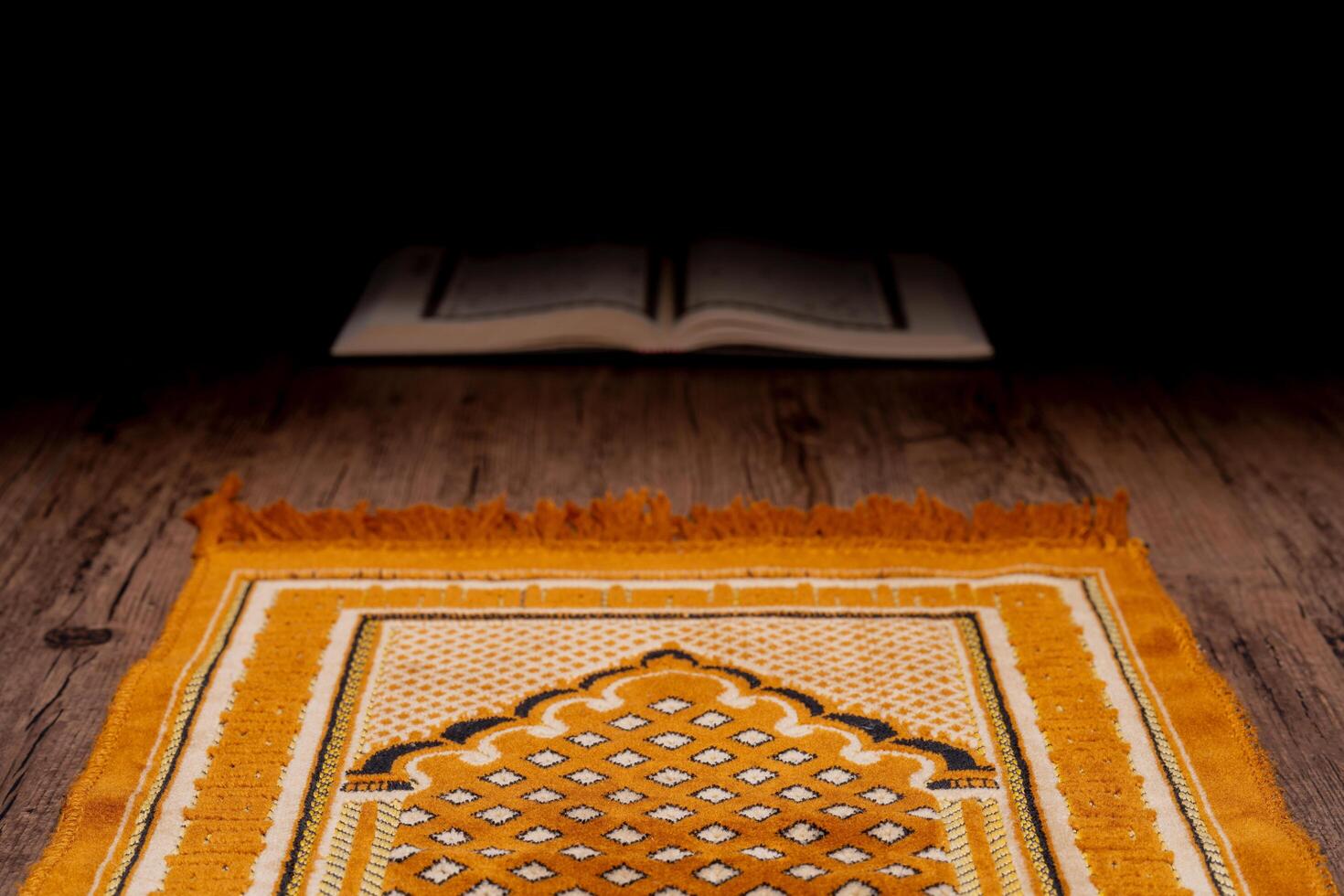 Islamic concept - The Holy Al Quran with written Arabic calligraphy meaning of Al Quran and rosary beads or tasbih and prayer rug, on wooden stand, with copy space. photo