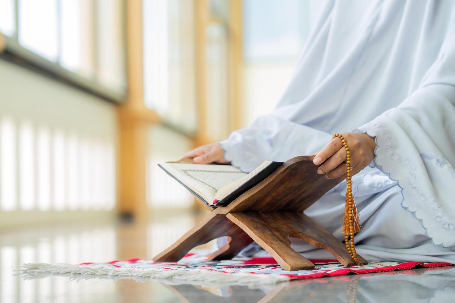 Islamic concept - The Holy Al Quran with written Arabic calligraphy meaning of Al Quran and rosary beads or tasbih photo
