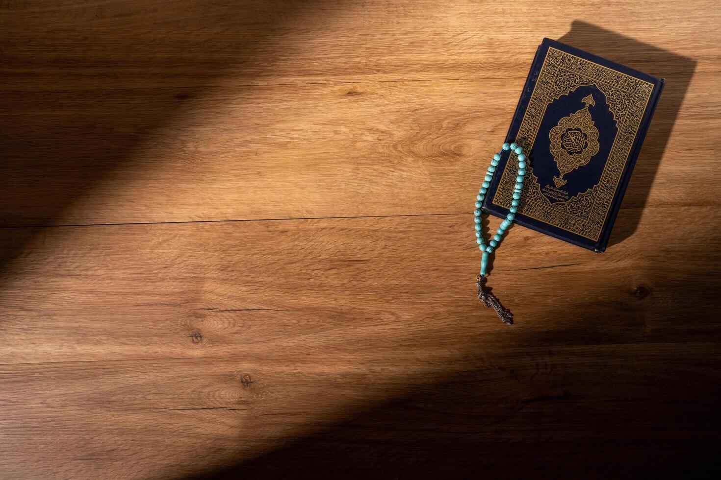 Islamic concept - The Holy Al Quran with written Arabic calligraphy meaning of Al Quran and rosary beads or tasbih photo