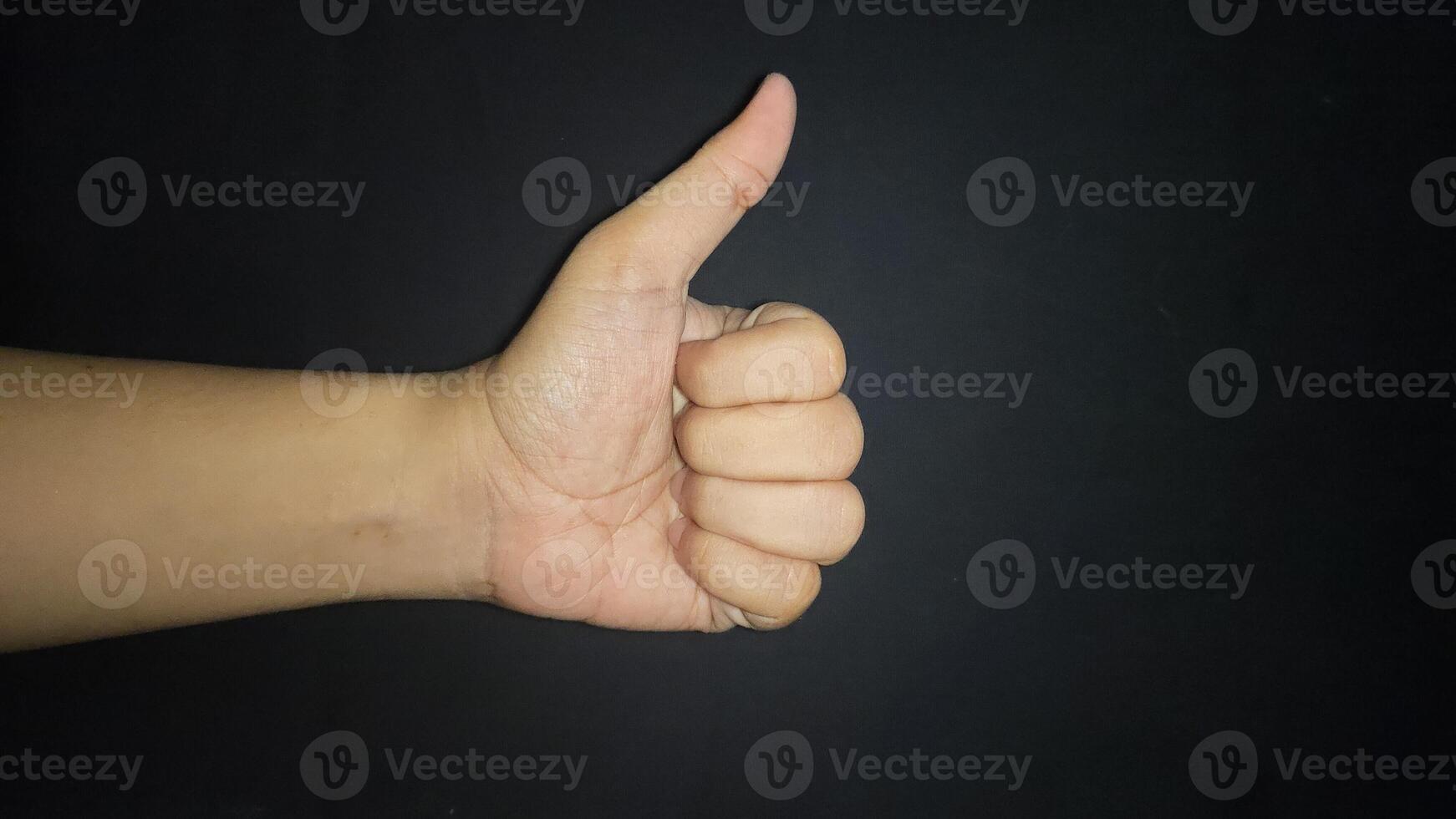 Hand thumb up isolated on black background photo
