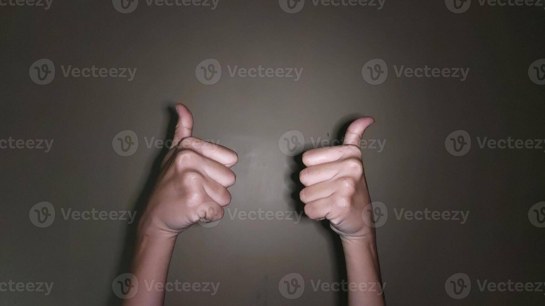 Raise both hands with a thumbs up gesture photo