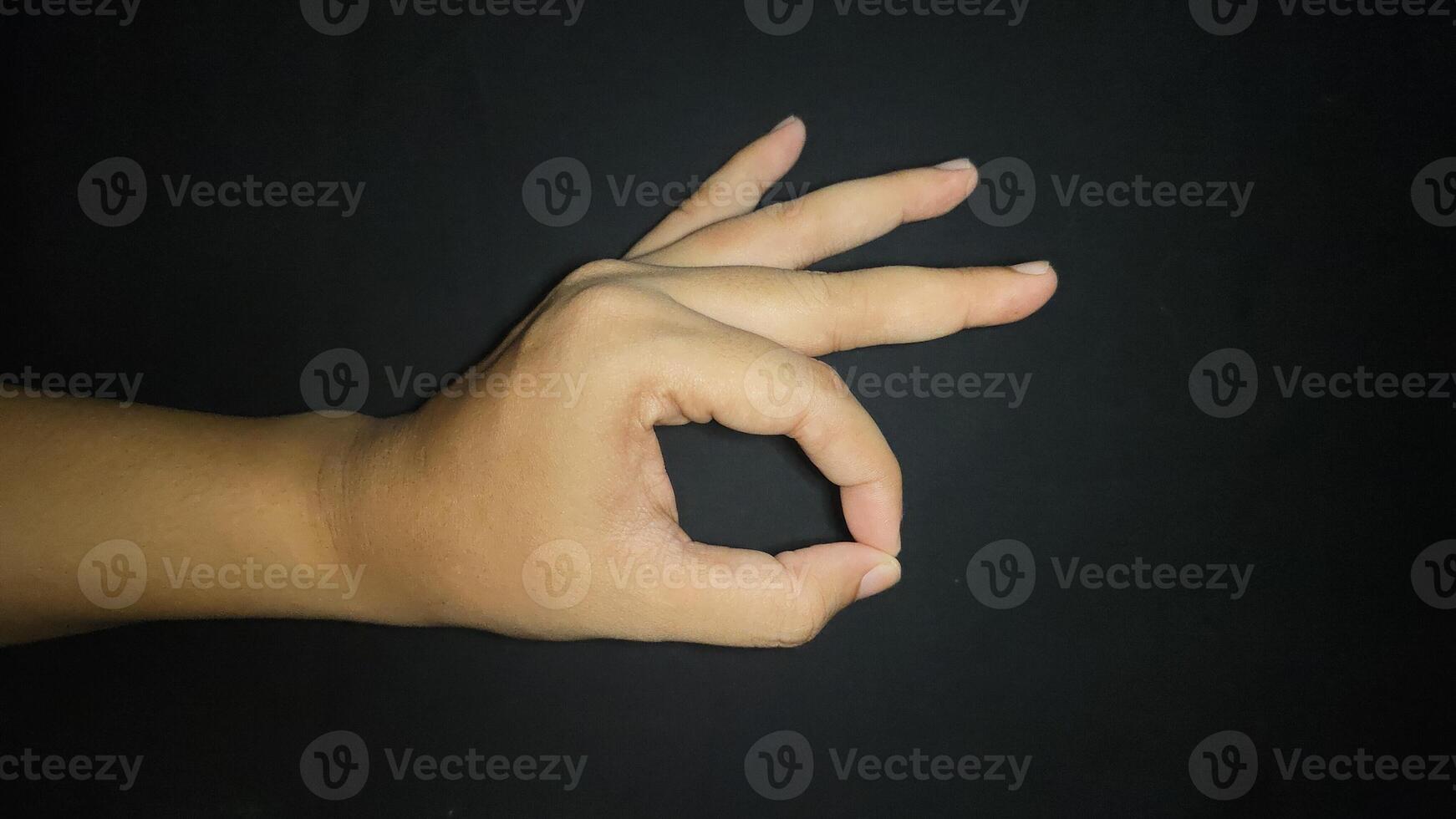 Ok hand sign isolated on black background photo