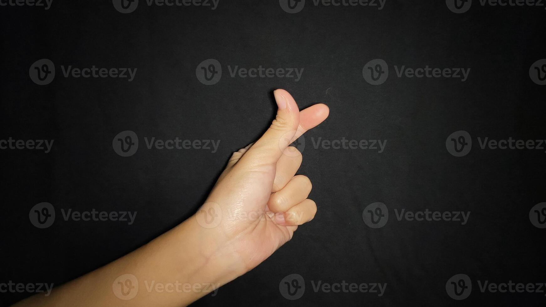 Hands with the Sarangheo gesture which means love.Isolated on black background photo