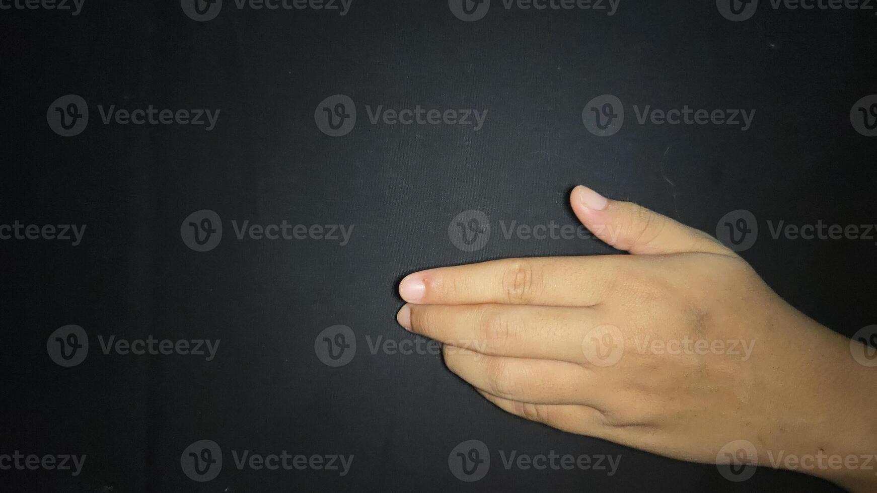 Offering a hand in a gesture inviting a handshake. Isolated on black background photo