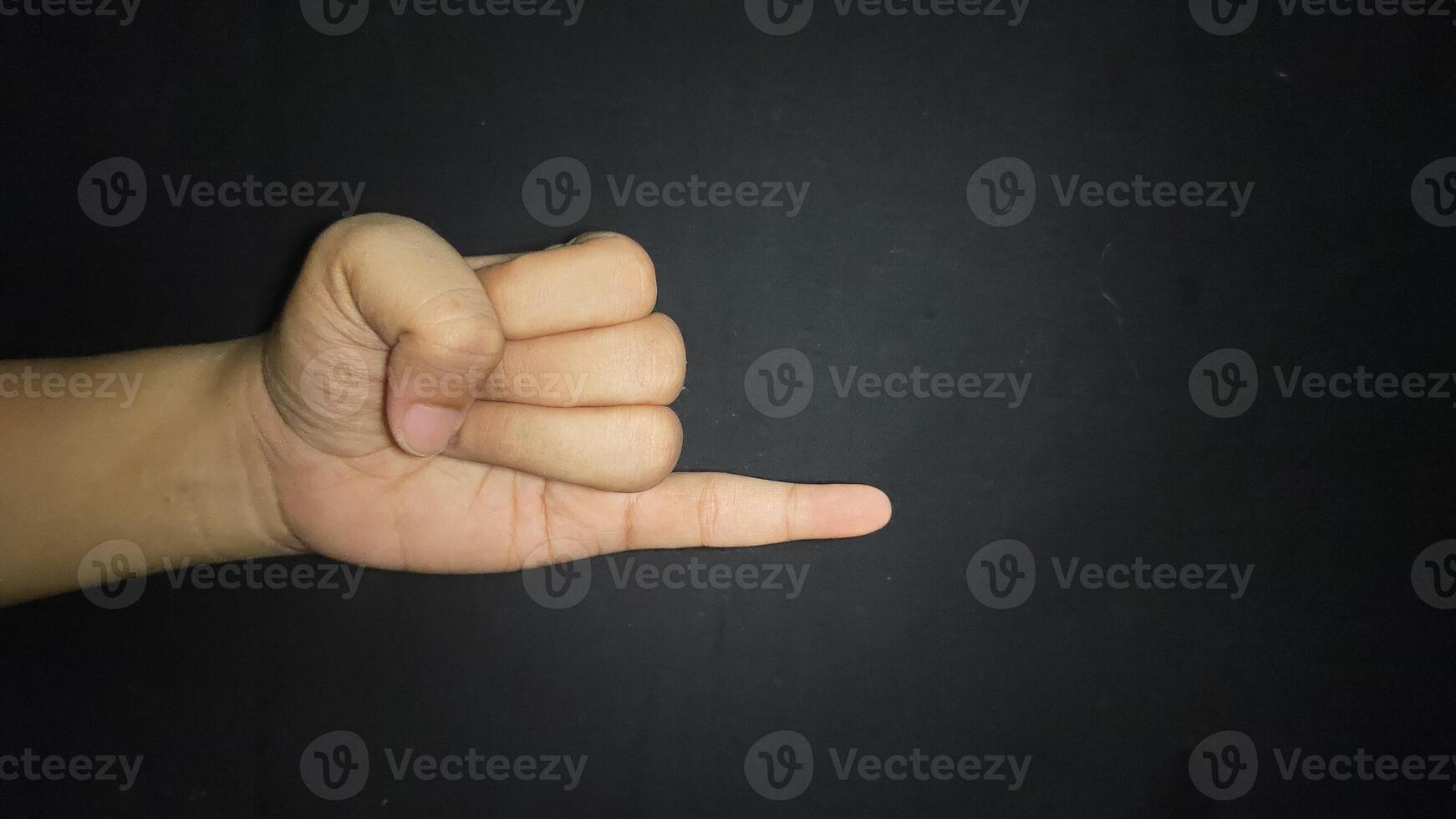Hand showing little finger.Isolated on black background photo