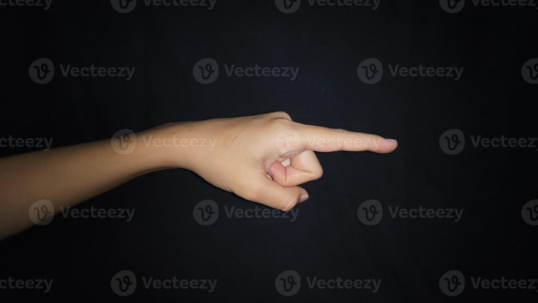 A hand showing a gesture pointing at something. Isolated on black background photo