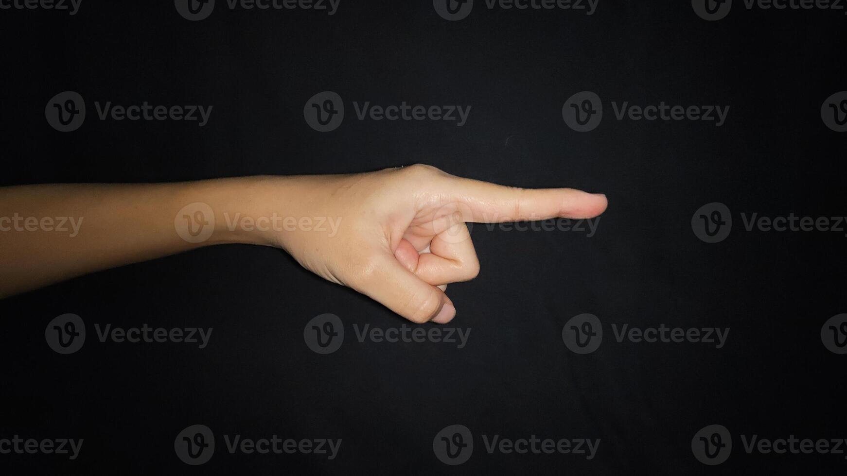 A hand showing a gesture pointing at something. Isolated on black background photo