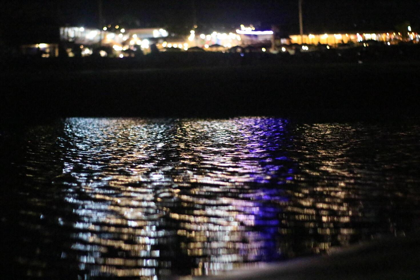 A view of the water at night with lights on photo