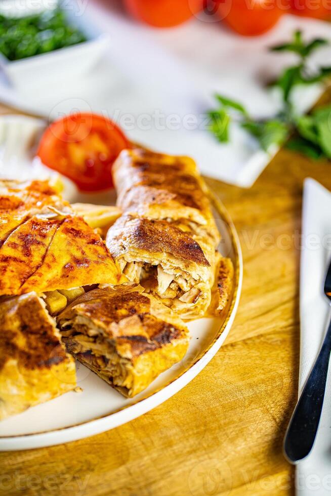 Chicken roll breast stuffed with butter, garlic and dill. Served with baked potato slices and fresh herbs. photo