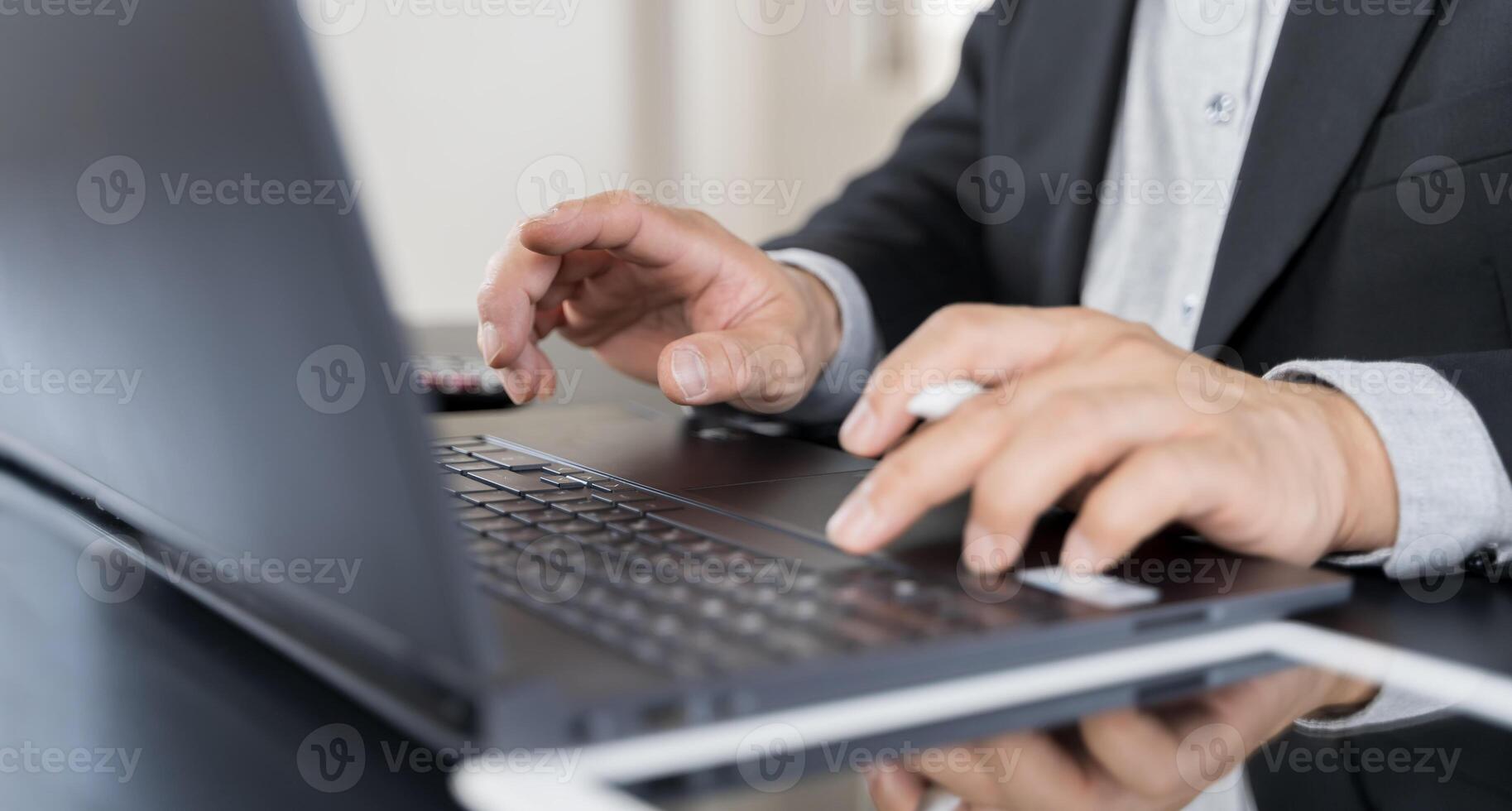 Businessmen having working on laptop computer, using digital tablet and mobile phone during meeting at office. photo