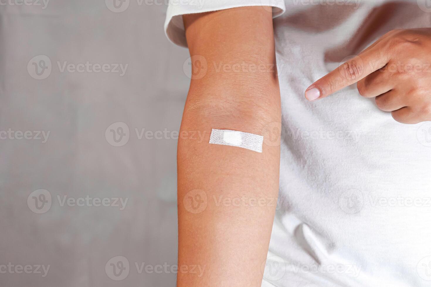 hand pointing to arm with injection marks photo