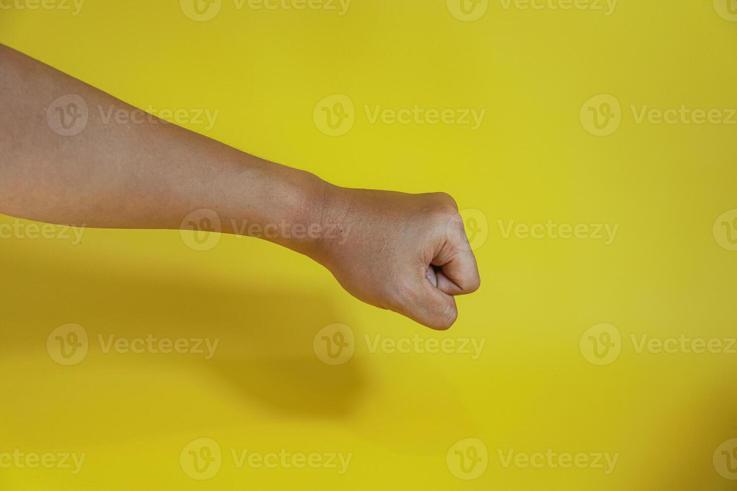 hand fist isolated on a yellow background photo