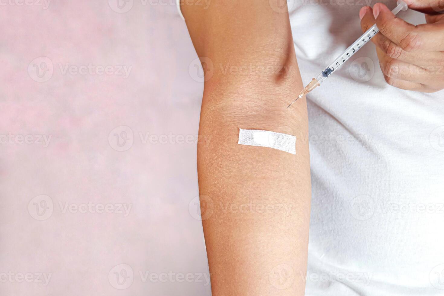 hand holding injection and showing injection marks photo