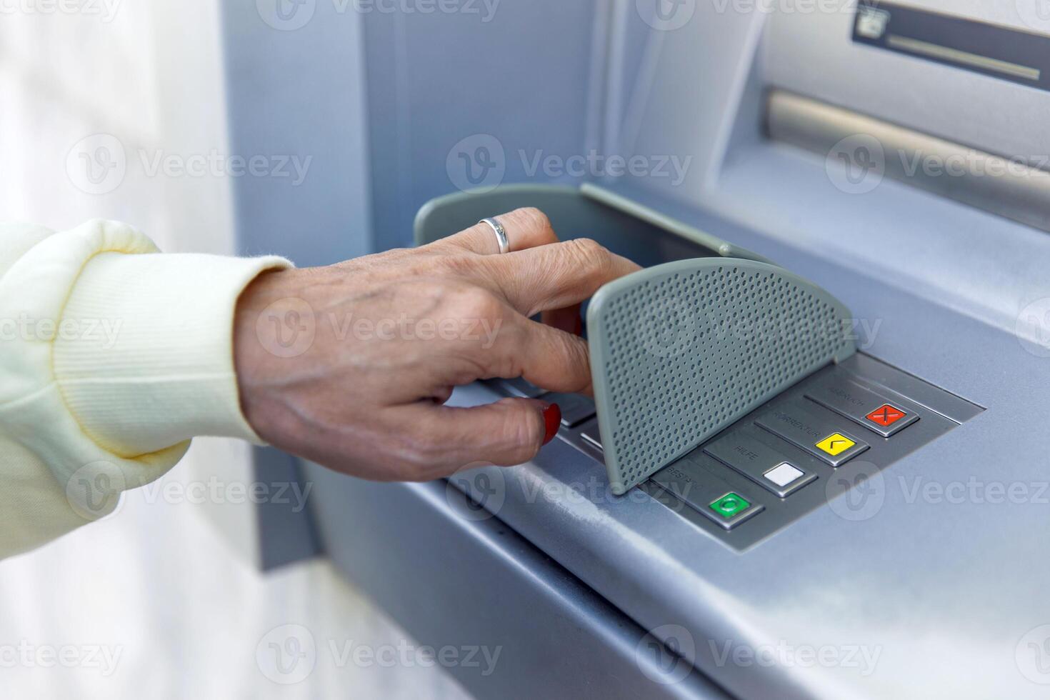 Person using atm keypad for secure banking transaction with finger on green button photo