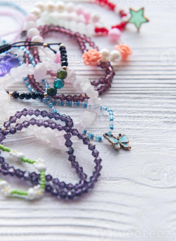 Colorful handmade beaded bracelets and accessories arranged on a wooden surface for a creative display photo