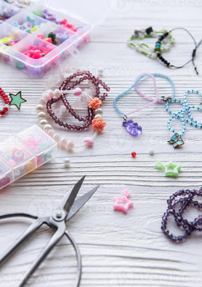 Crafting colorful jewelry with beads and charms on a wooden table during a creative afternoon photo