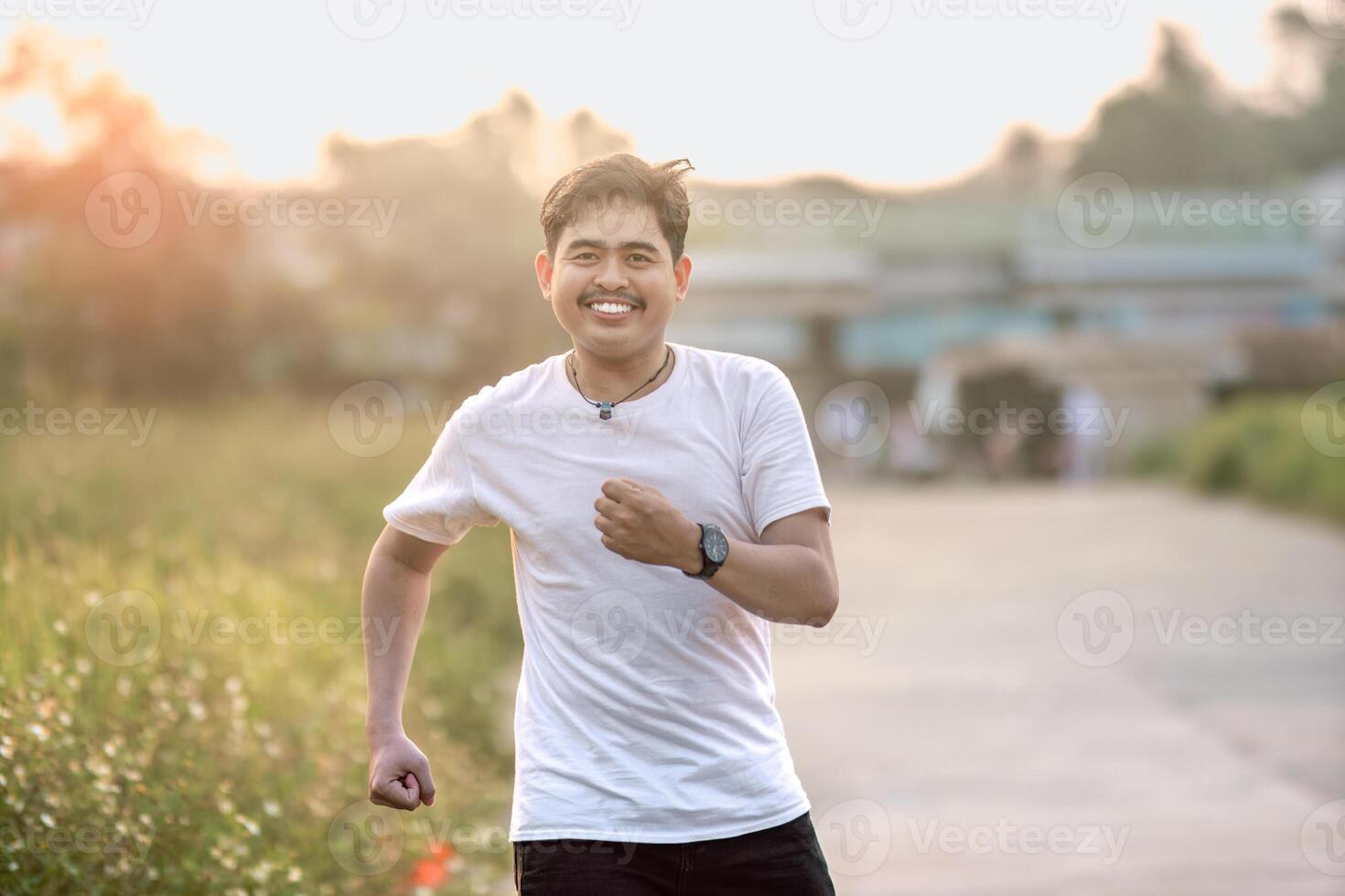a man who stood and smiled goofily. The man acted like he was running. set in nature on a sunny afternoon. photo