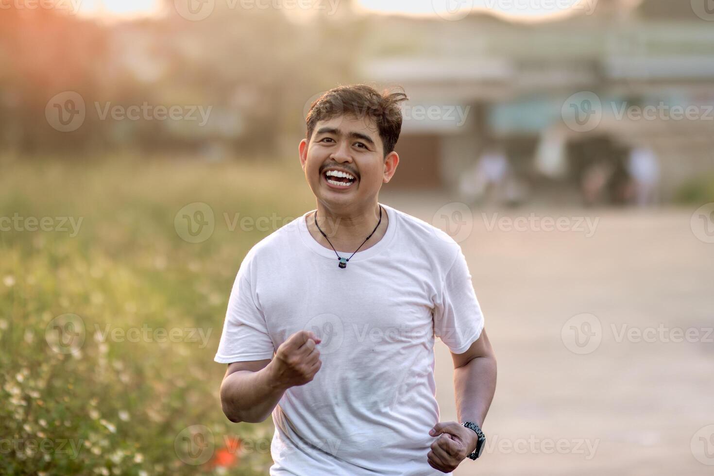 a man who stood and smiled goofily. The man acted like he was running. set in nature on a sunny afternoon. photo